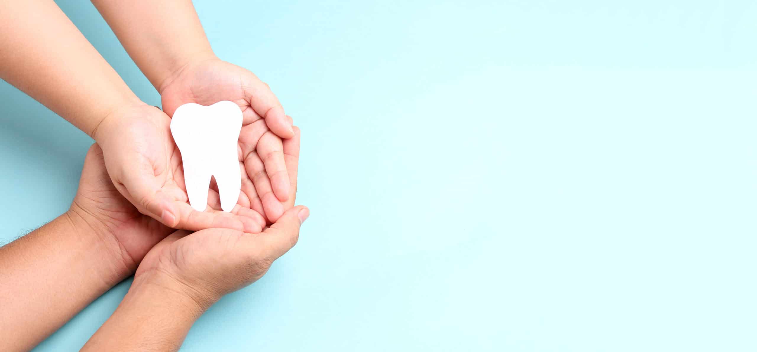 hands-holding-paper-teeth-blue-scaled